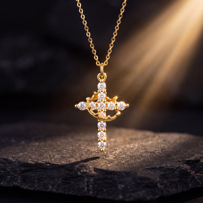 Collar Cruz y Corona – rayo de luz dorada sobre piedra oscura