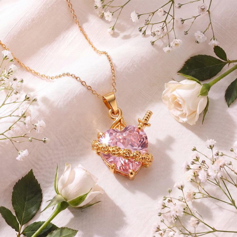 Collar Corazón Sagrado Luz de María – corazón rosado talla gema con rosas doradas y espada, entre rosas